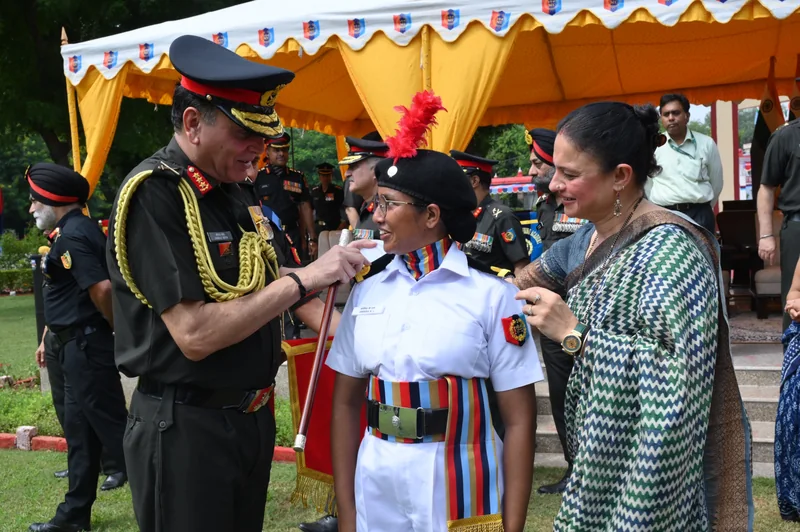 सफेद वर्दी और काली बेरेट में महिला NCC सहभागी के पास खड़े वरिष्ठ अधिकारी
